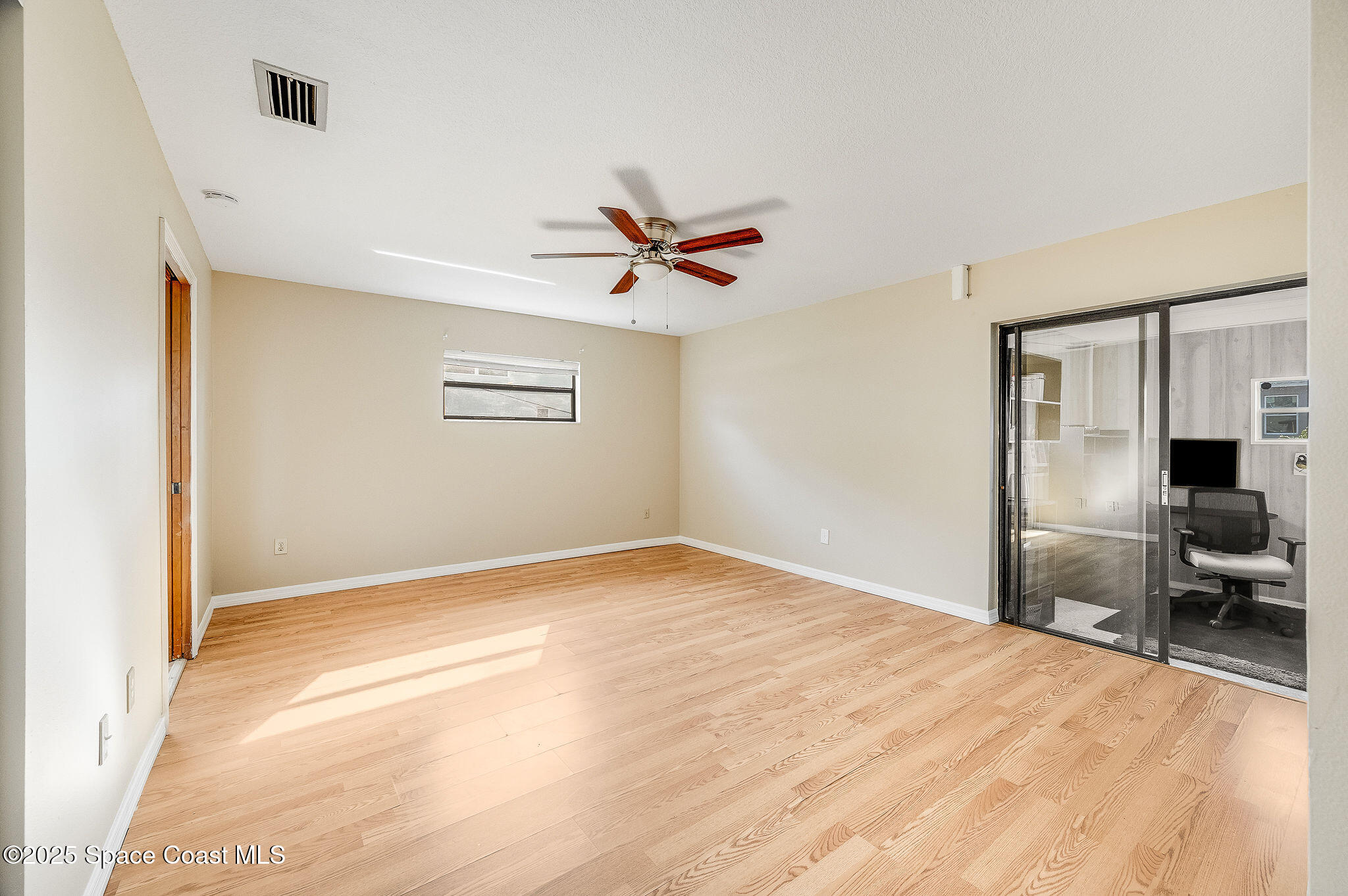 115 Angelo Road Southeast Palm Bay, FL 32909 - Photo 8 of 38 a view of empty room with wooden floor and fan