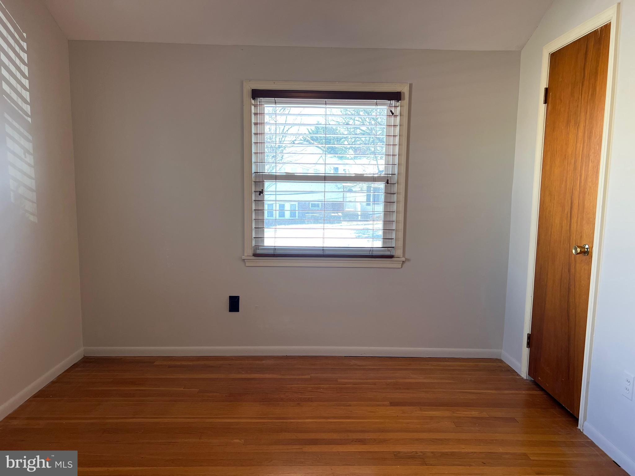 5808 Nystrom Street Hyattsville, MD 20784 - Photo 17 of 38 a view of an empty room with wooden floor and a window