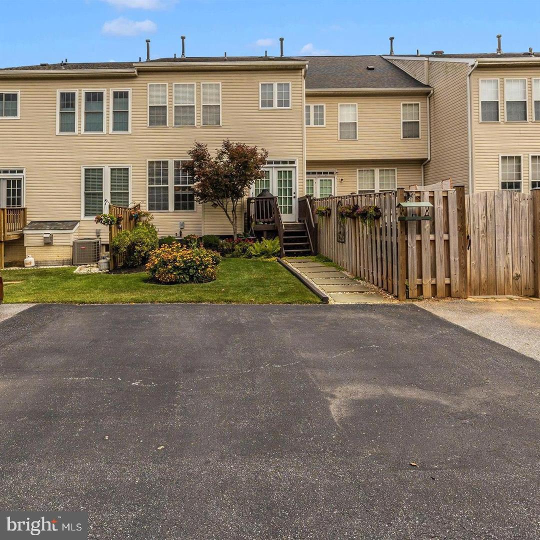 1731 Derrs Square West Frederick, MD 21701 - Photo 18 of 23 a view of a house with a yard and table and chairs under an umbrella