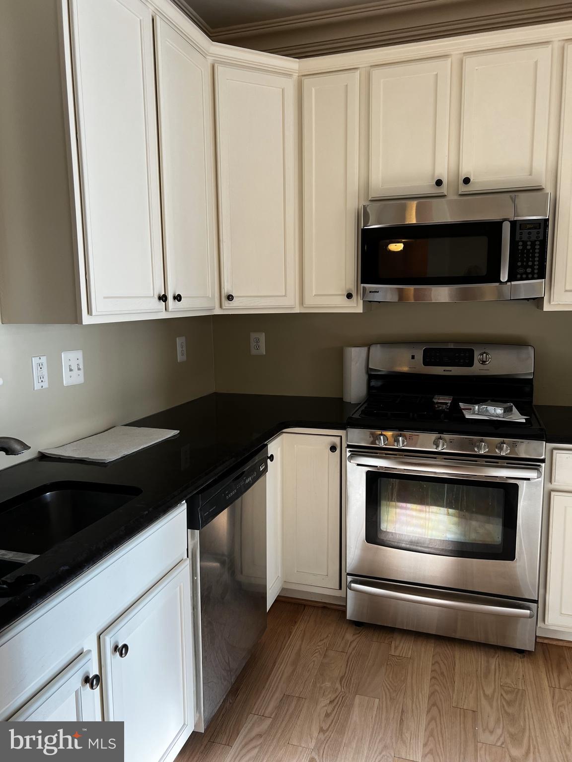 1731 Derrs Square West Frederick, MD 21701 - Photo 2 of 23 a kitchen with granite countertop white cabinets and black appliances