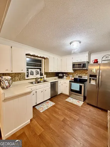 a kitchen with cabinets stainless steel appliances and a counter space