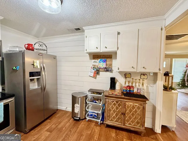 a kitchen with a refrigerator and a stove top oven