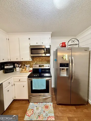 a kitchen with stainless steel appliances granite countertop a refrigerator a stove and a sink