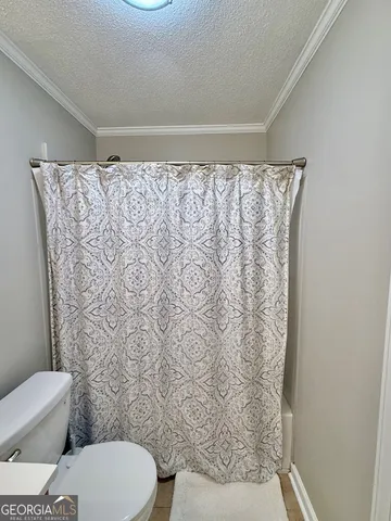 a white toilet sitting next to a shower curtain