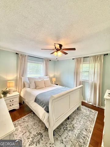 a bedroom with a bed and a dresser with rug