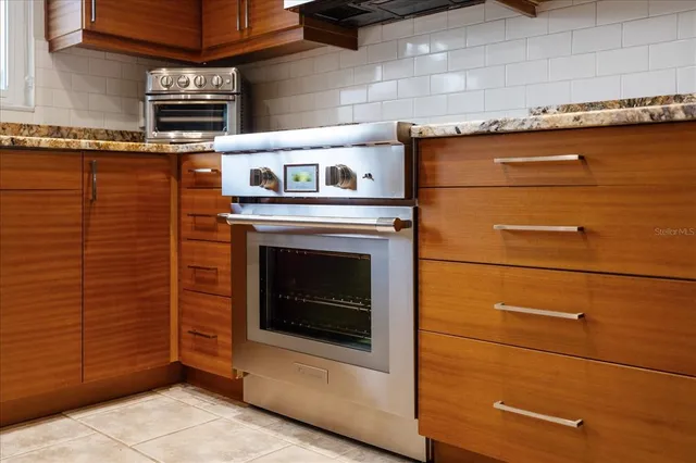 a stove top oven sitting inside of a kitchen