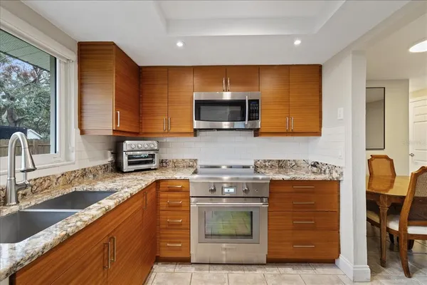 a kitchen with stainless steel appliances granite countertop wooden cabinets a stove top oven a sink and dishwasher
