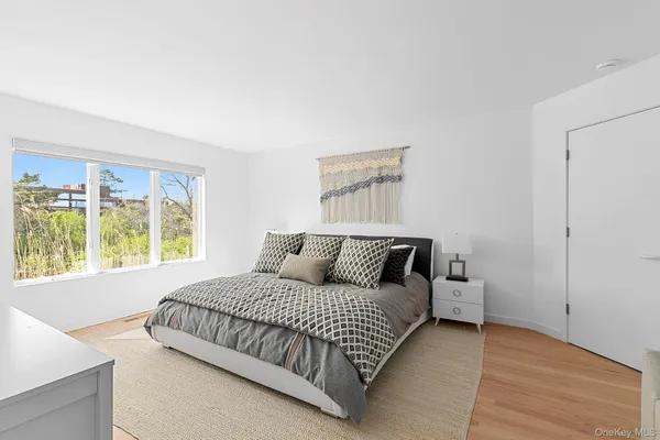 a bedroom with a bed and a large window