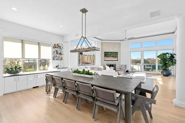 a view of a dining room and livingroom with furniture wooden floor a chandelier
