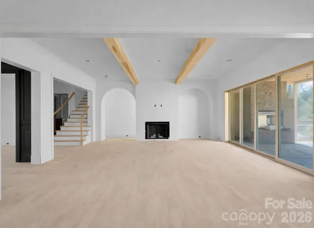 a view of an empty room with a fireplace and a window