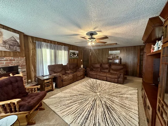 a living room with furniture fireplace and a large window