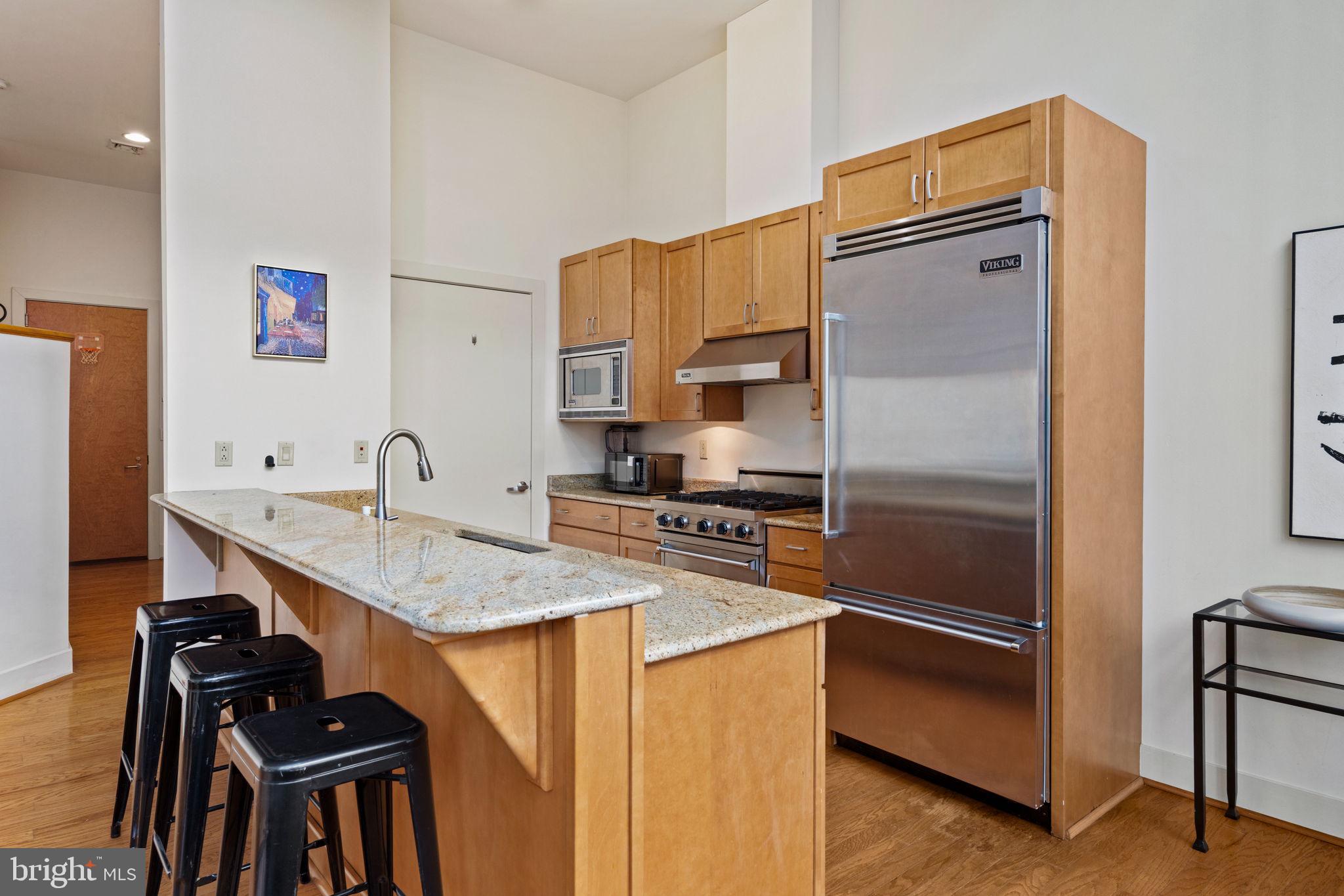 23 South 23rd Street, Unit 3D Philadelphia, PA 19103 - Photo 15 of 37 a kitchen with stainless steel appliances granite countertop a refrigerator a sink and a stove