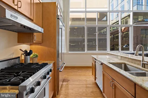 a kitchen with stainless steel appliances granite countertop a refrigerator and a sink