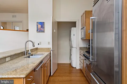 a kitchen with stainless steel appliances granite countertop a sink and a refrigerator