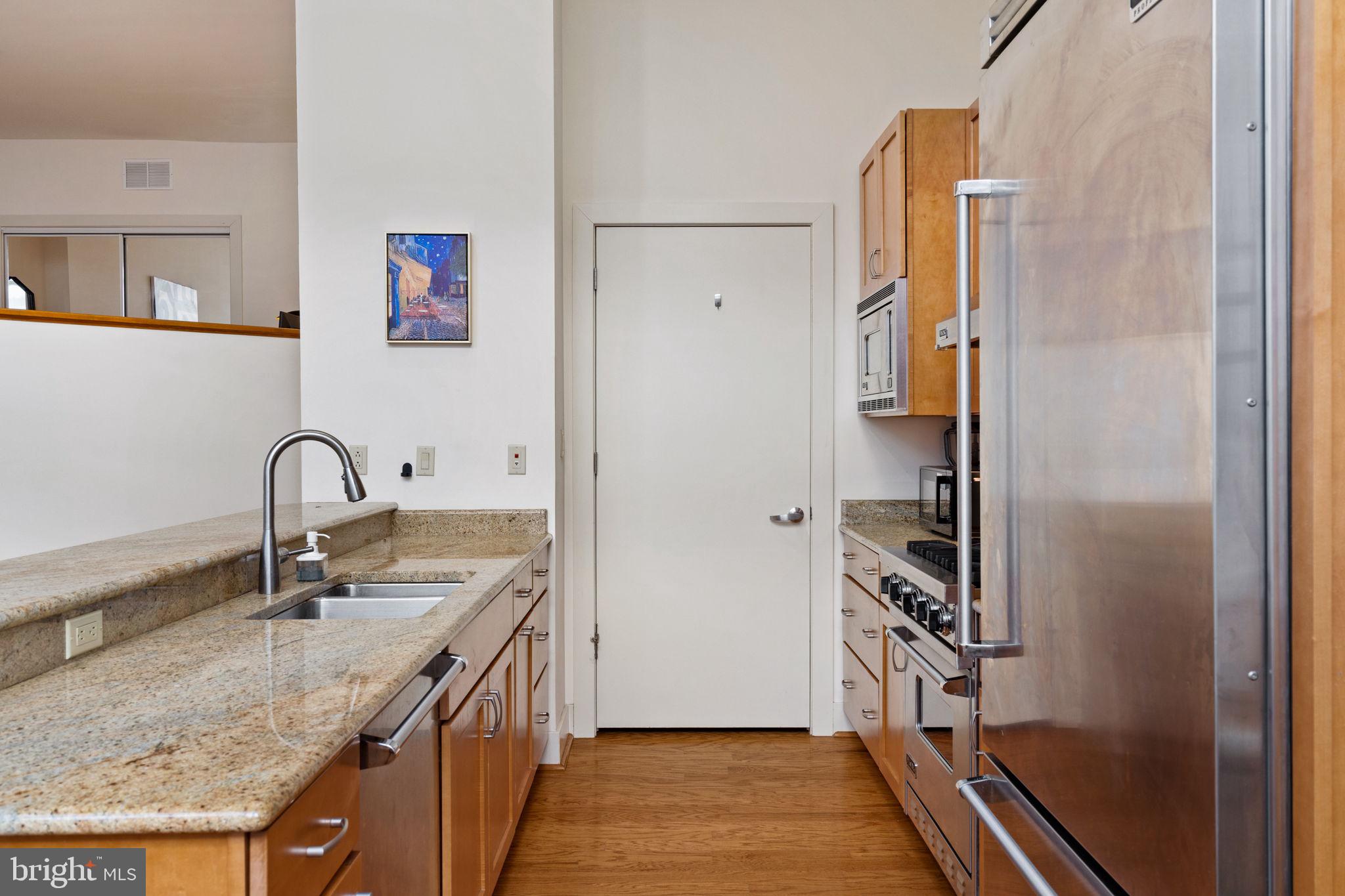 23 South 23rd Street, Unit 3D Philadelphia, PA 19103 - Photo 19 of 37 a kitchen with stainless steel appliances granite countertop a sink and a refrigerator