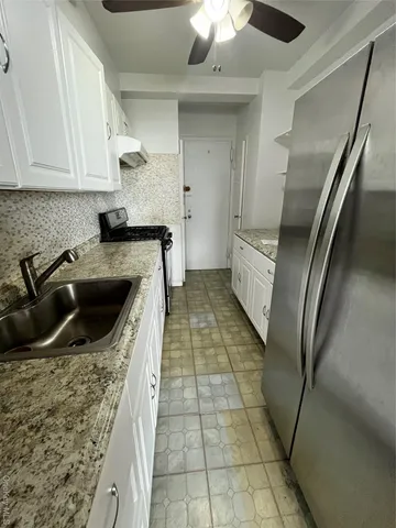 a kitchen with a sink a faucet and cabinets