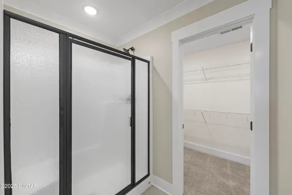 a bathroom with a glass shower door and a sink
