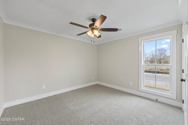 an empty room with a window and a fan