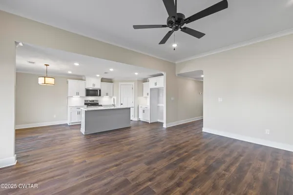 a view of kitchen with kitchen island wooden floor center island and stainless steel appliances