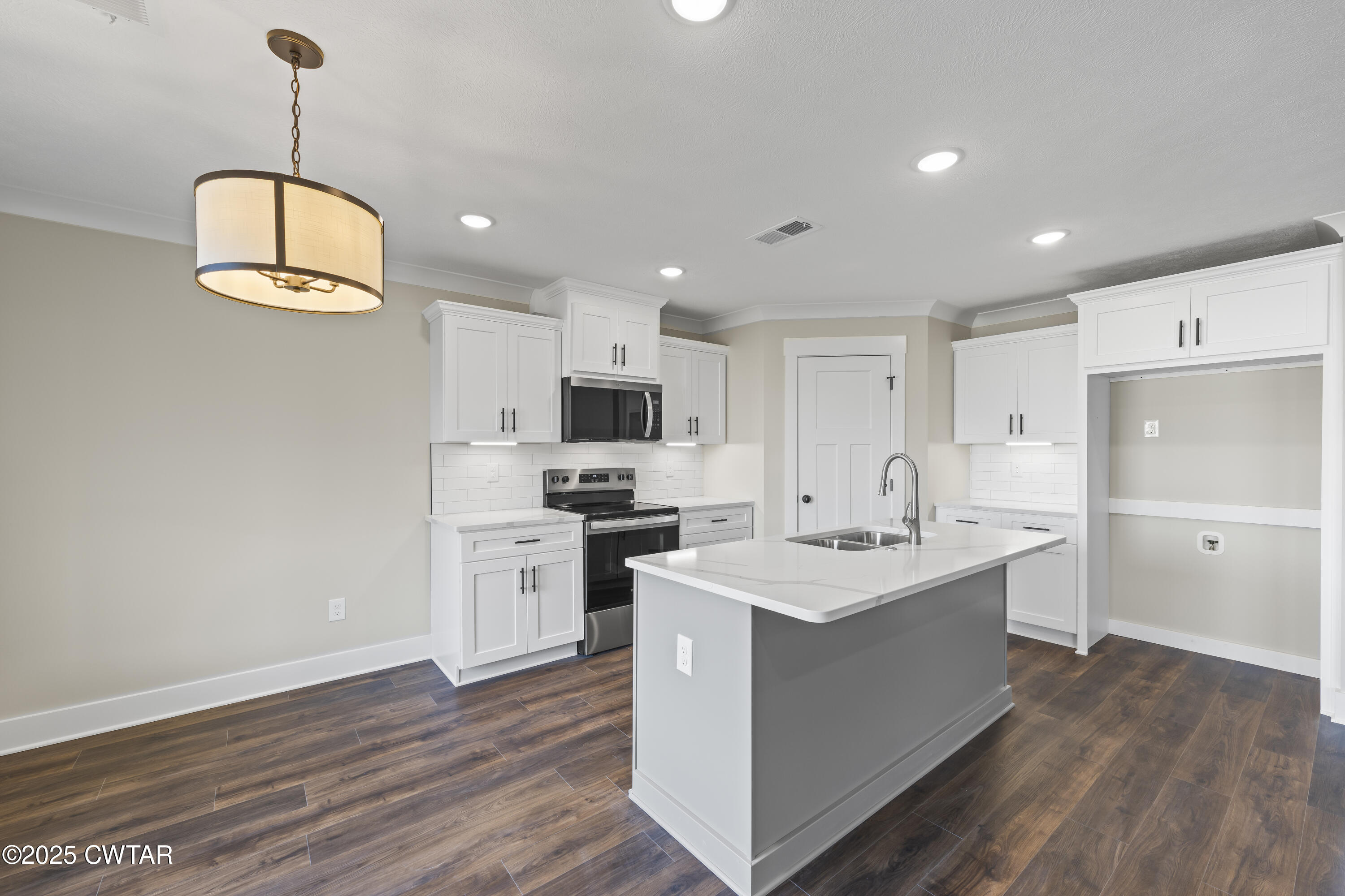 5 Easington Cove Jackson, TN 38305 - Photo 8 of 17 a kitchen with stainless steel appliances a stove a sink dishwasher a refrigerator white cabinets and wooden floor next to a window