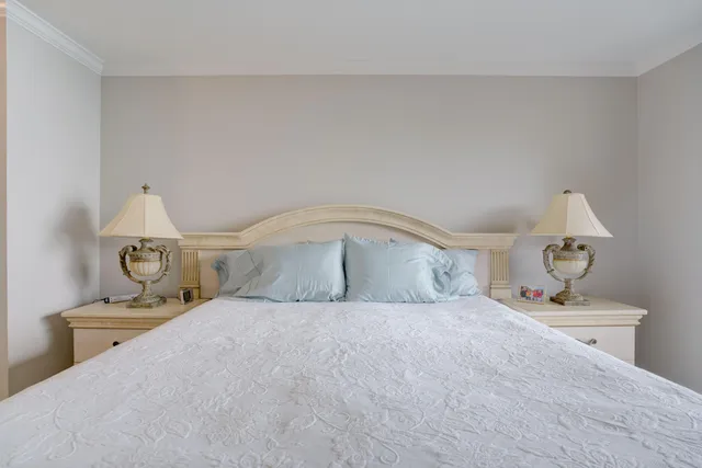 a bedroom with a large bed and a chandelier