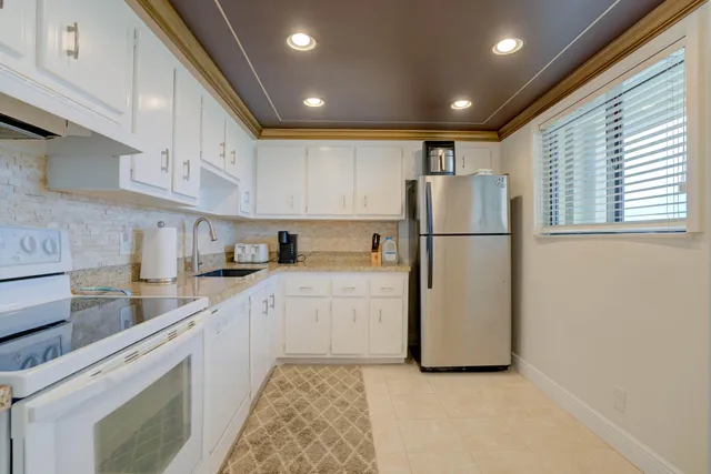 a kitchen with granite countertop white cabinets stainless steel appliances and sink