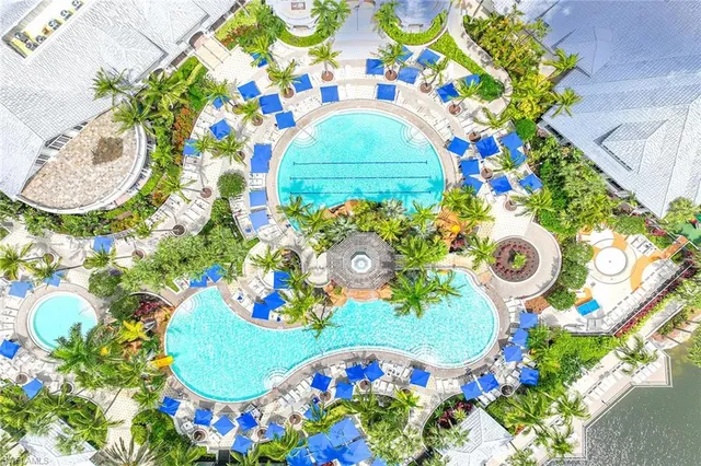 a small pool with lawn chairs and a table