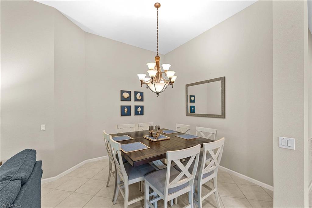 3975 Deer Crossing Court, Unit 201 Naples, FL 34114 - Photo 12 of 35 a dining room with a table and chairs
