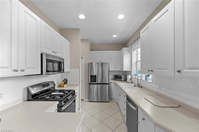 a kitchen with white cabinets and a stove top oven