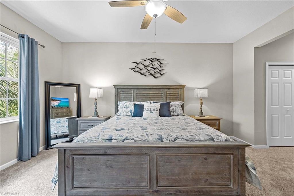 3975 Deer Crossing Court, Unit 201 Naples, FL 34114 - Photo 16 of 35 a bedroom with a bed and a chandelier