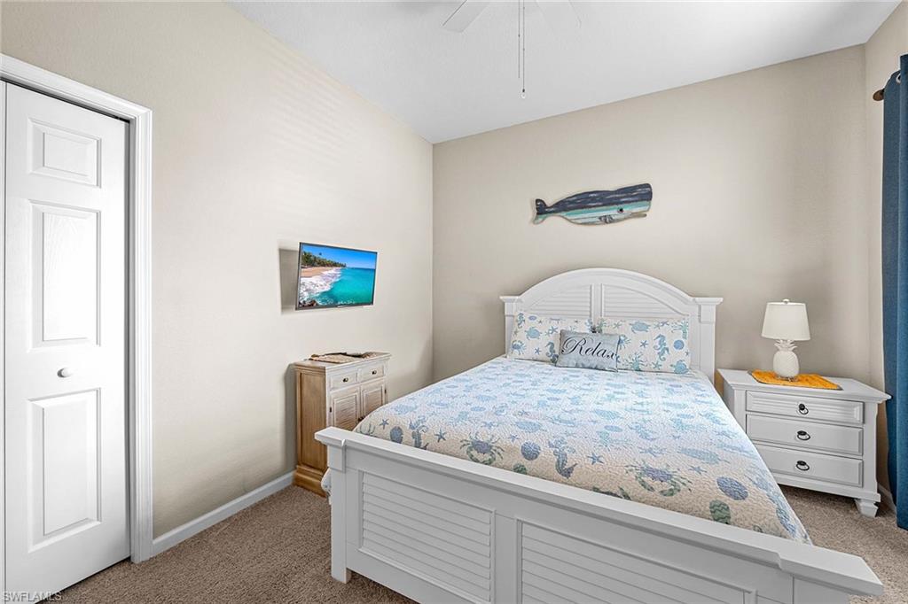 3975 Deer Crossing Court, Unit 201 Naples, FL 34114 - Photo 22 of 35 a bedroom with a bed and a lamp