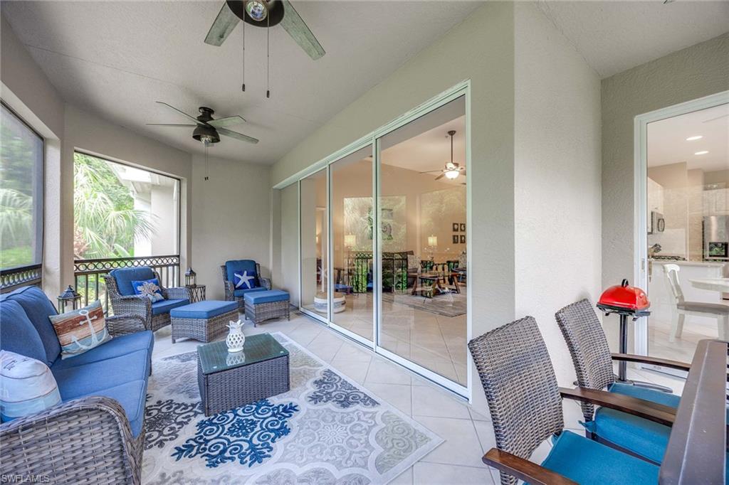 3975 Deer Crossing Court, Unit 201 Naples, FL 34114 - Photo 26 of 35 a living room with furniture and a large window