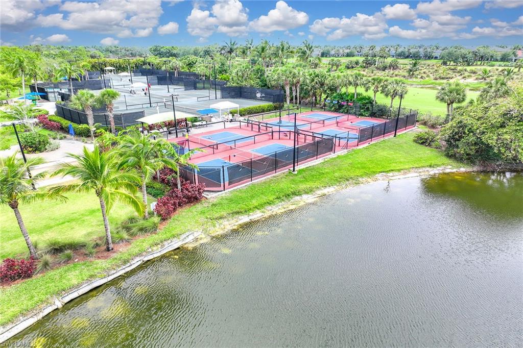3975 Deer Crossing Court, Unit 201 Naples, FL 34114 - Photo 33 of 35 a view of a swimming pool with a yard and a garden