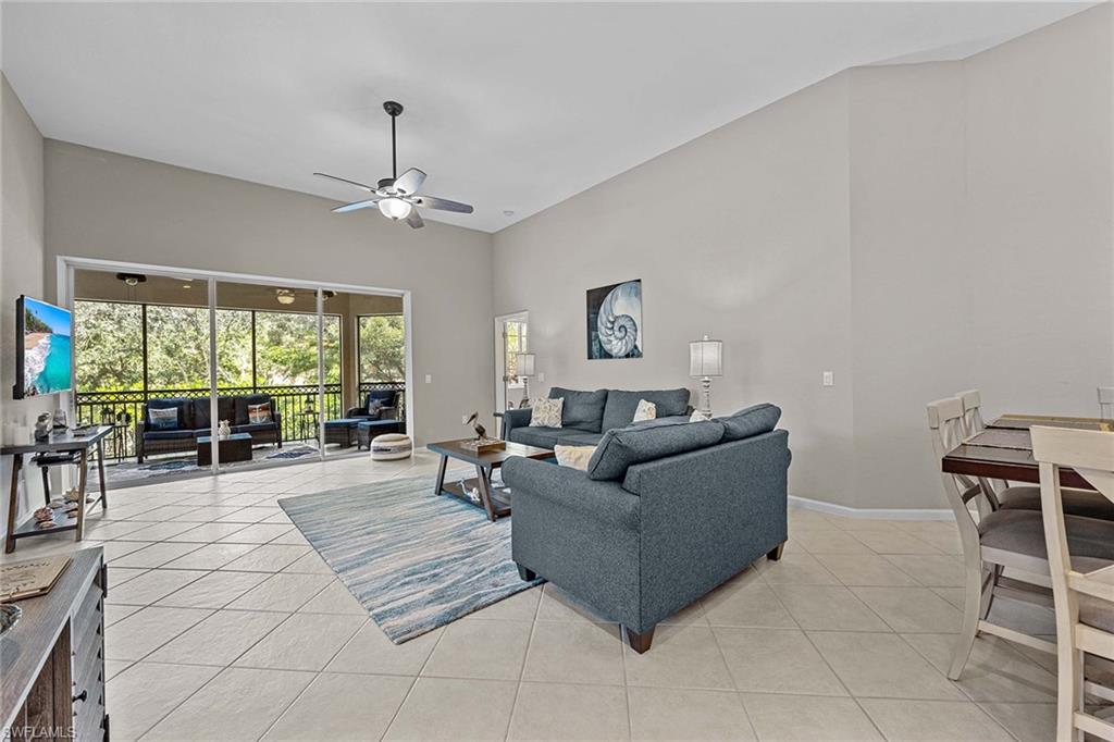 3975 Deer Crossing Court, Unit 201 Naples, FL 34114 - Photo 8 of 35 a living room with furniture and a large window