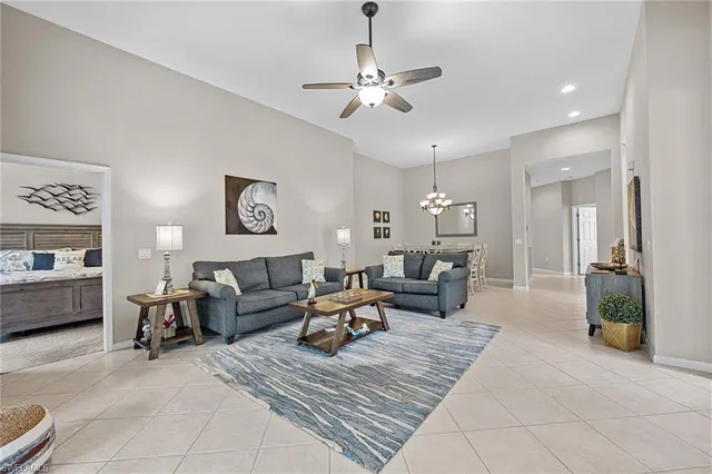 a living room with furniture a chandelier and a flat screen tv