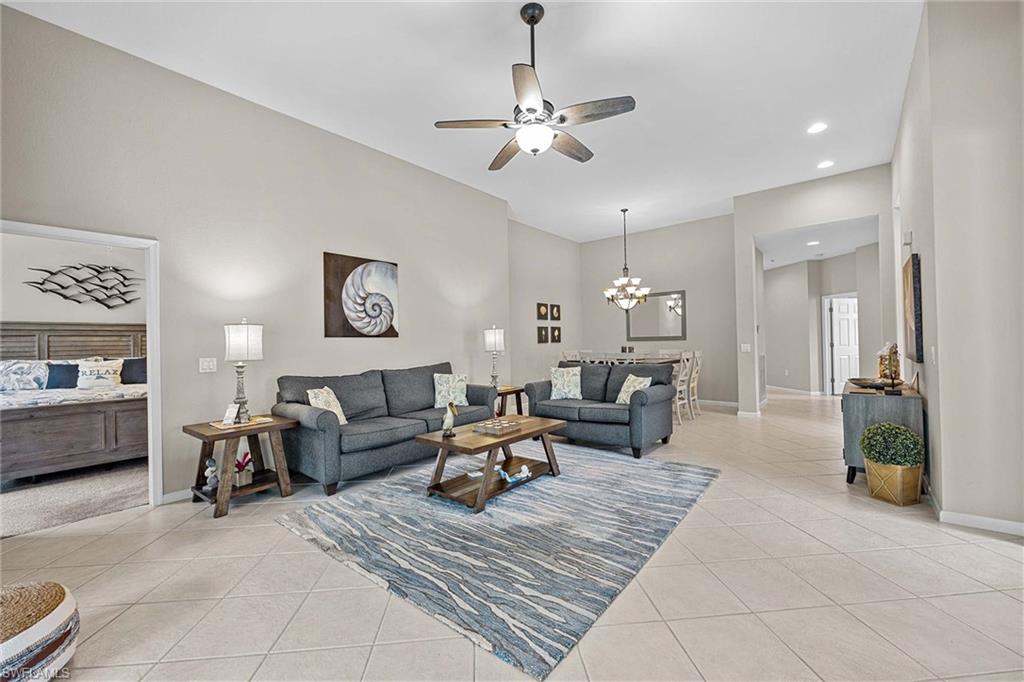 3975 Deer Crossing Court, Unit 201 Naples, FL 34114 - Photo 9 of 35 a living room with furniture and a chandelier
