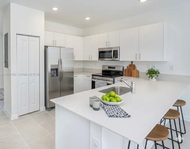 a kitchen with stainless steel appliances a refrigerator sink and microwave