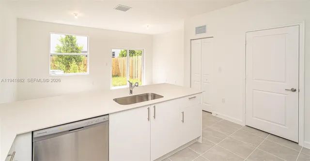 a living room with furniture a flat screen tv and a floor to ceiling window