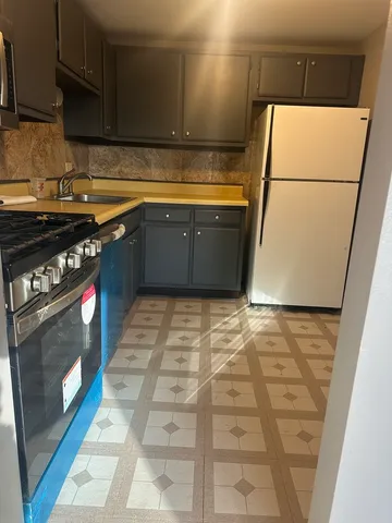 a kitchen with granite countertop a stove and a refrigerator