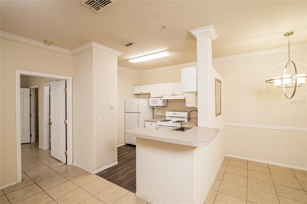 3391 South Kirkman Road, Unit 1216 Orlando, FL 32811 - Photo 7 of 33 a kitchen with kitchen island a counter top space appliances and cabinets