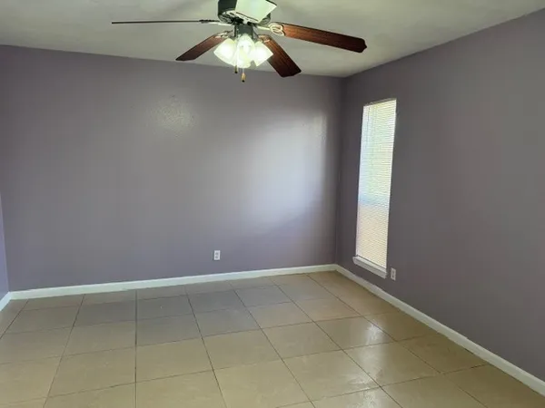 en empty room with windows and fan