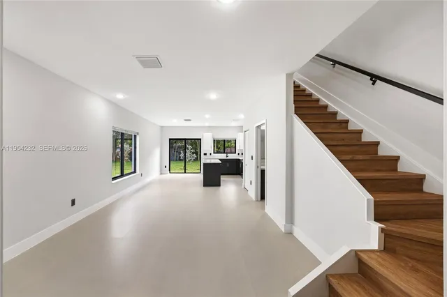 a view of a livingroom with wooden floor and stairs