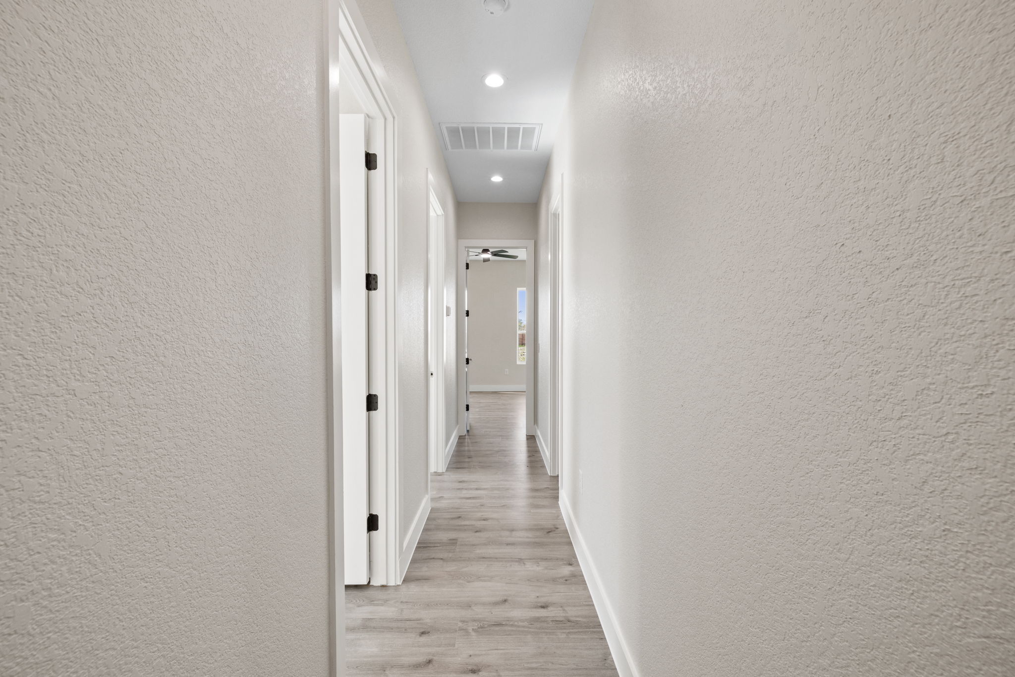 210 Jacaranda Drive Dale, TX 78616 - Photo 19 of 37 a view of a hallway with wooden floor and a bathroom