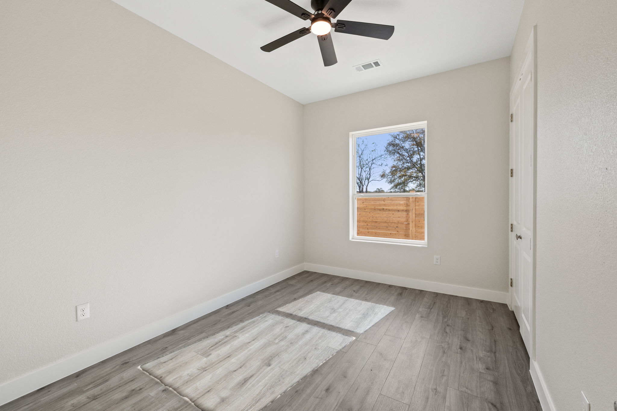 210 Jacaranda Drive Dale, TX 78616 - Photo 20 of 37 an empty room with wooden floor and windows