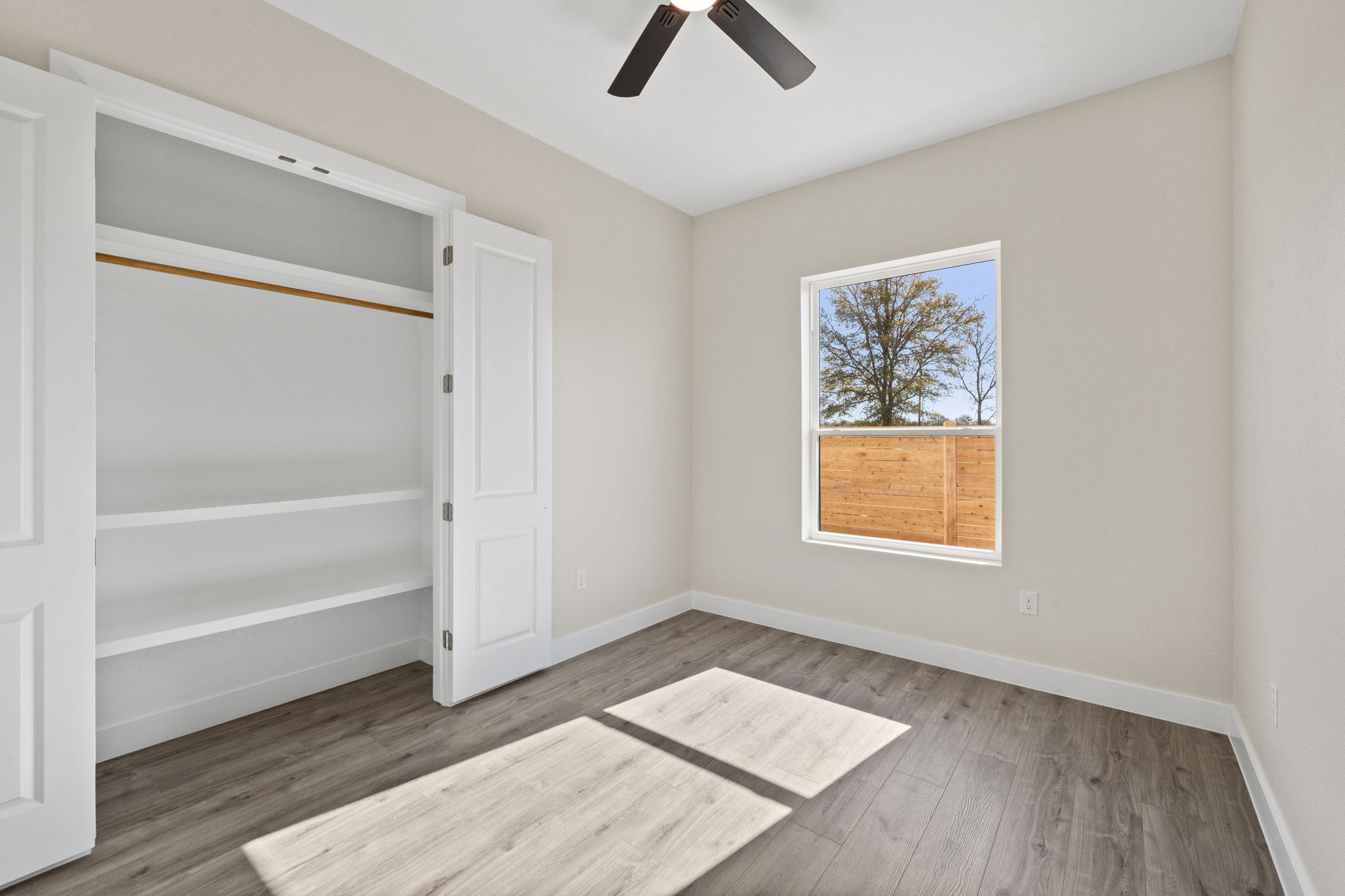 210 Jacaranda Drive Dale, TX 78616 - Photo 24 of 37 a view of an empty room with a window and wooden floor