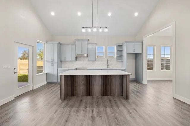 a kitchen with kitchen island a sink stainless steel appliances and cabinets