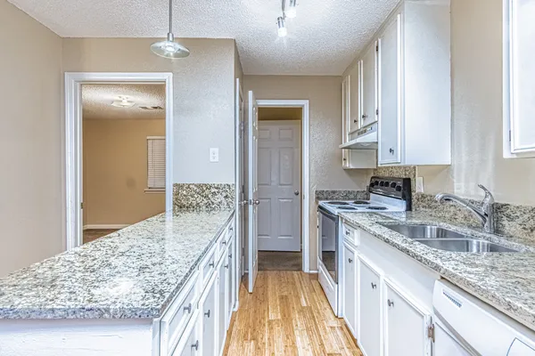a bathroom with a granite countertop sink and shower