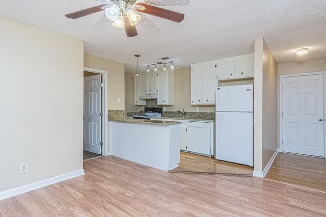 a kitchen with a refrigerator and a stove top oven