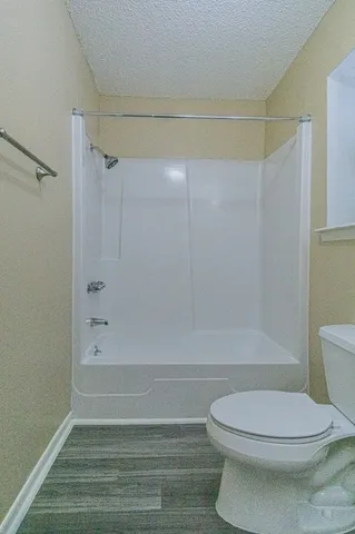 a bathroom with a toilet and a shower