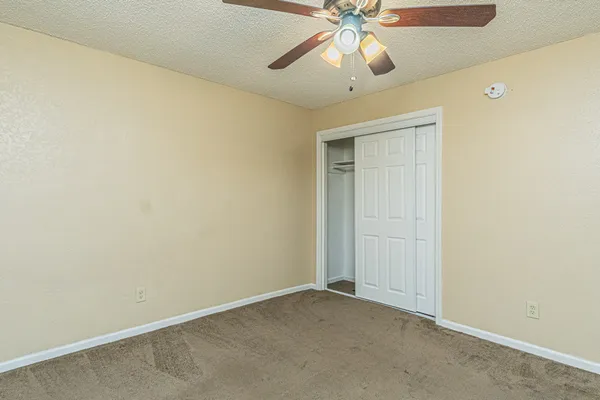 an empty room with a fan and a fan
